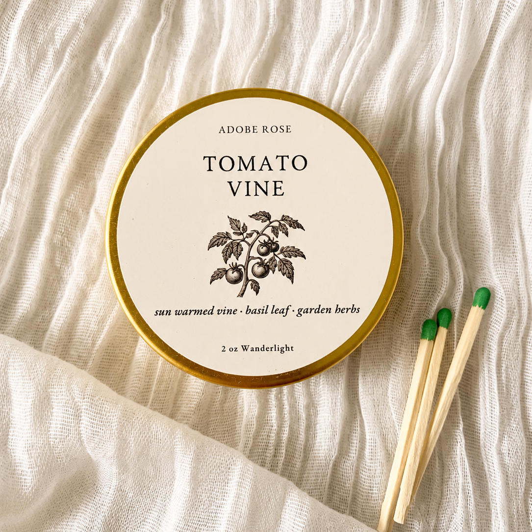 Tomato Vine candle tin with matches on a textured fabric background