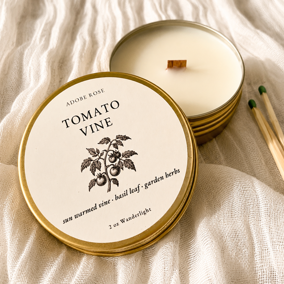 Candle with 'Tomato Vine' label on a textured fabric background